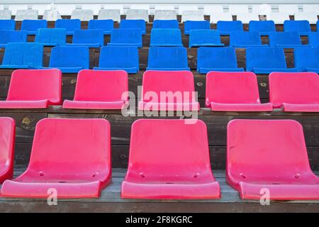 Several rows of plastic seats in red, blue and white colors in the color of the russian flag, mounted on brown-painted wooden platforms on the podium Stock Photo