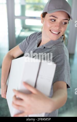 young happy female deliverywoman smiling Stock Photo