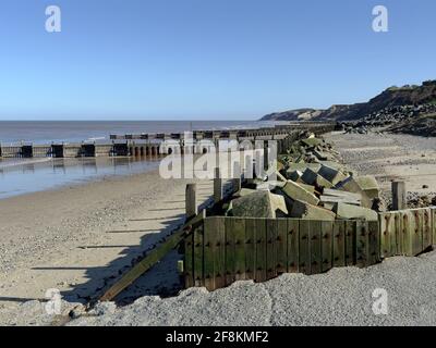 Sea defences protecting the beach and cliffs at the popular residential and holiday village of Overstrand on the North Norfolk coast. Stock Photo