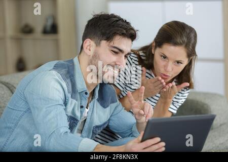 couple gesturing to person on video chat Stock Photo