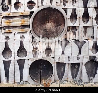 Worn out and burnt wooden glass molds. Stack of used wooden glass shaping tools and moulds to be used when blowing glass. Glass design studio Kunratic Stock Photo