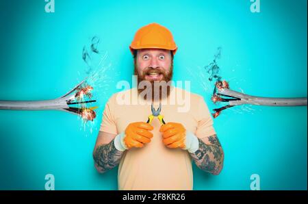 Incompetent worker electrician is unsure about his work. cyan background Stock Photo