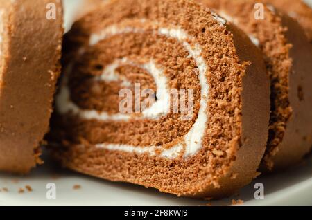 Chocolate sponge roll with a vanilla flavour filling, chocolate swiss roll, swirled cake Stock Photo