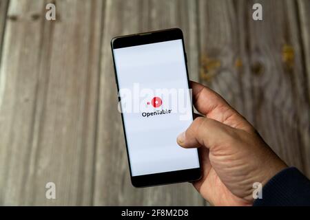 A Mobile phone or Cell phone being held in a hand showing the open table app on screen Stock Photo