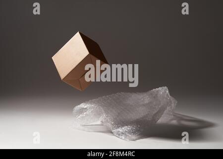 Cardboard box and bubble wrap on dark background Stock Photo
