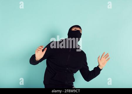 Thief with balaclava was spotted trying to steal in a apartment. Scared expression Stock Photo