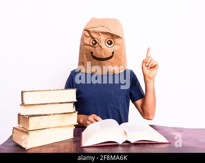 Happy mature man finding the solution to what he was looking for in a book pointing with his finger, isolated on background. Stock Photo