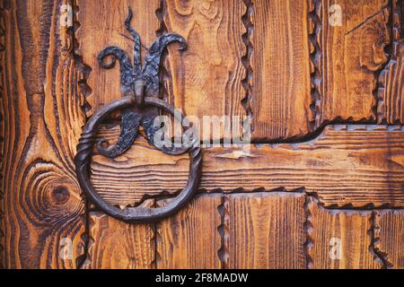 Iron knocker or ring handle on old wooden door Stock Photo