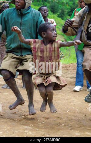 Jumping for joy! Young girl living near Bugambira, Uganda, dancing with friends and family. East Africa. Stock Photo