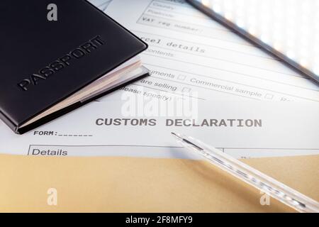 a Passport over Customs Declaration form. customs Agent concept. Planning a deal or shipping item parsel on post. Close up Stock Photo