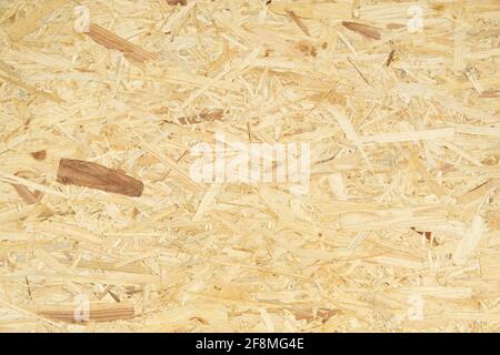 OSB wall panel  Sheet of plywood with fragments of compressed sawdust, textured surface Wooden grain background Stock Photo