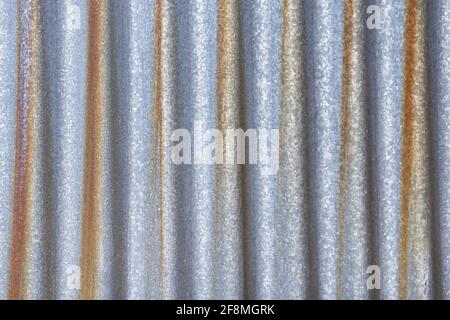 Rusty  galvanized zink steel fence  wall or iron metal sheet asia surface. Rust on Corrugated texture and background. Stock Photo