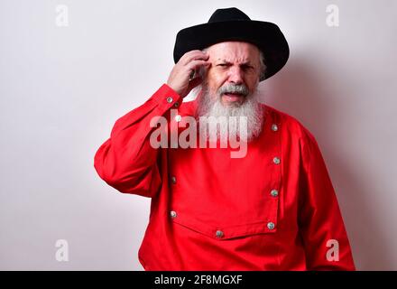 Retired American male with red western bib shirt scratching his head and frowning Stock Photo