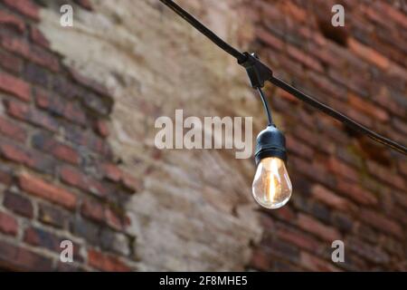 Close up of a party light against a brick wall. Stock Photo