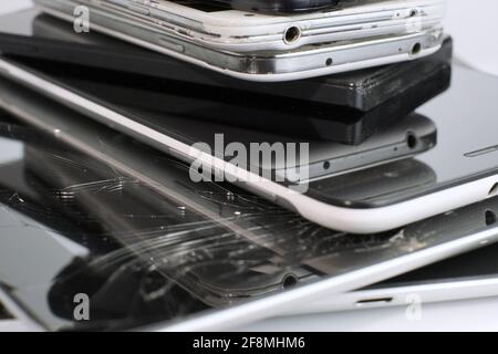 Broken Mobile Smart Phone and pad with crashed Screen Glass Lcd.  gadgets lying one on top of another. Devices are prepared for utilization. Stock Photo
