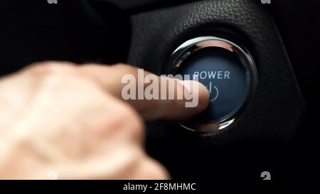 pushing blue  power ignition button to start keyless ignition hybrid car engine Stock Photo