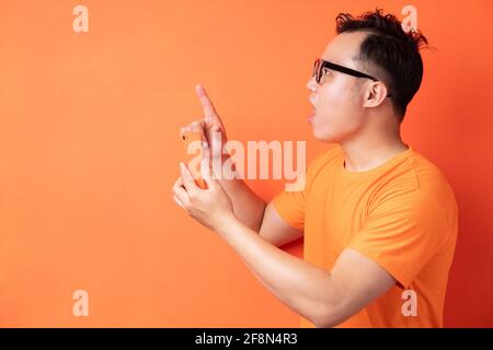 Young Asian man holding the phone with a surprised expression Stock Photo