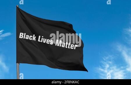 Text Black Lives Matter by white letters on black flag against blue sky Stock Photo