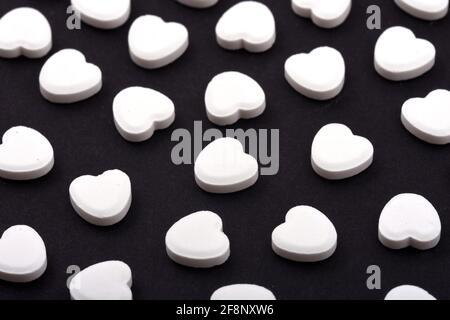 Heart shaped pills on a black background Medicines that help people
