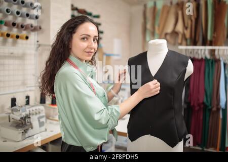 Dressmaker with Mannequin As Professional Fashion Designer. Female  Dressmaker Adjusting Clothes on Tailoring Mannequin and Smiling Stock Photo  - Image of entrepreneur, dressmaker: 146550678