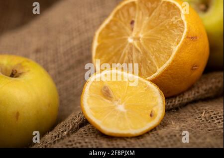 Sliced lemon and fresh green apples on a homespun cloth with a rough texture. Close-up selective focus. Stock Photo