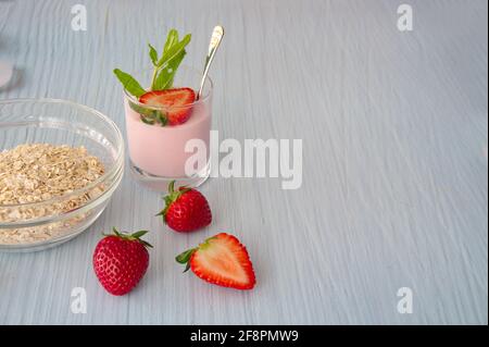 Oat flakes with smoothie of strawberries on light background Stock Photo