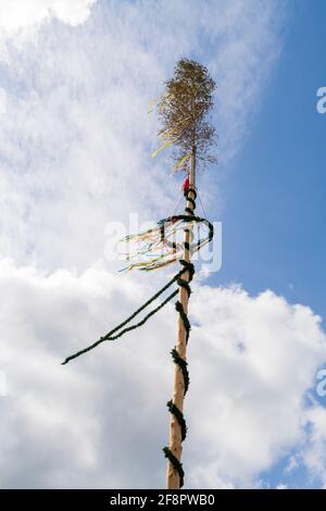 A maypole against blue sky with clouds Stock Photo