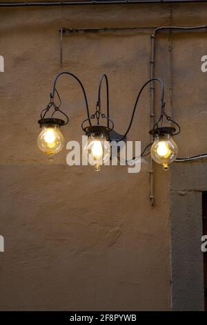 Three Wrought Iron Lights on Exterior Wall Stock Photo