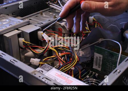 Male hand working on the inside of a computer, computer repair concept Stock Photo