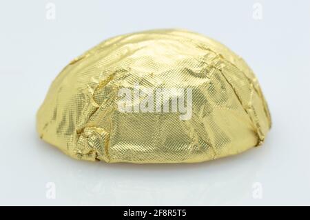 chocolate candy in a gold shiny package on a white background . isolated, close-up Stock Photo