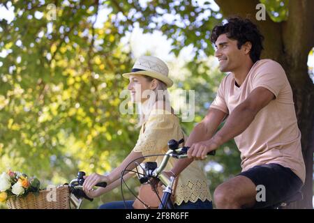 couple riding bikes on an empty road Stock Photo