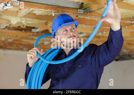 a plumber checking ceiling pipes Stock Photo