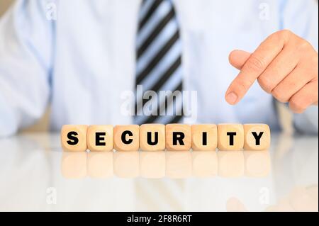 Businessman with the catchphrase SECURITY written on wooden cubes Stock Photo