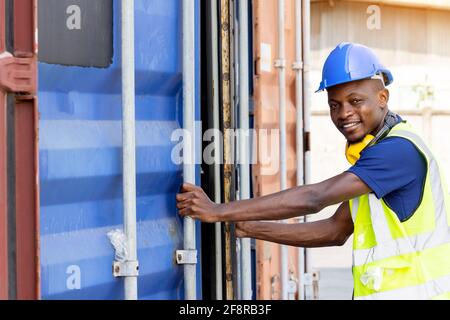 African-American black workers are opening containers for inspection and check that repairs have been completed in containers Stock Photo