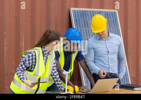 Outdoor shot of black African engineer inspect electrical solar panel wearing hardhat, protective eyeglass and safety equipment, Stock Photo