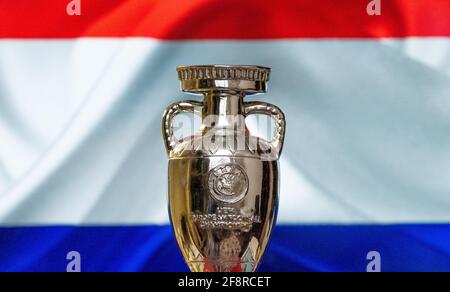 April 10, 2021. Amsterdam, Holland. UEFA European Championship Cup with the Netherlands flag in the background. Stock Photo