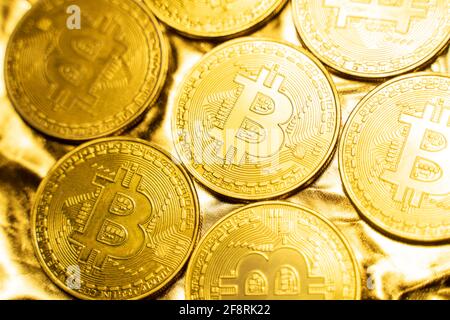 Golden bitcoin Coins on a golden background. Trading on the cryptocurrency exchange. Cryptocurrency Stock Market Concept. Virtual money concept Stock Photo