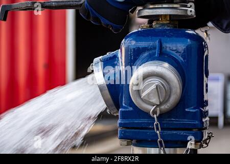 Close up of Water flowing from in open blue fire hydrant Stock Photo