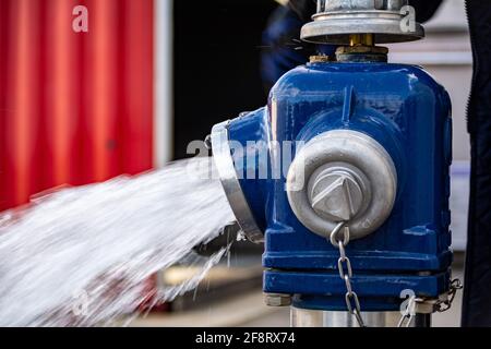 Close up of Water flowing from in open blue fire hydrant Stock Photo
