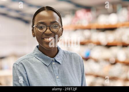 Young African woman smiling while standing in her warehouse Stock Photo