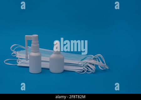 Nasal spray, throat spray, medical masks on a blue background. Copy space for text Stock Photo
