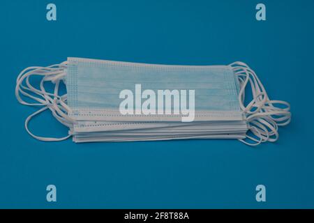 A stack of medical masks. On a blue background. close-up Stock Photo