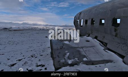 View of plane wreckage of a DC-3 (C-117) military airplane on Solheimasandur beach on the south coast in winter season with sparse, snow-covered lands Stock Photo