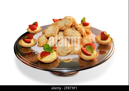 Pasta di meliga, cookies made with corn flour and butter on steel plate with strawberry pastries. Piedmontese biscuits, Italy, Isolated on white Stock Photo
