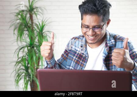 happy young asian man working on laptop with copy space  Stock Photo