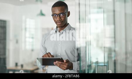 Confident young African businessman using a digital tablet at work Stock Photo