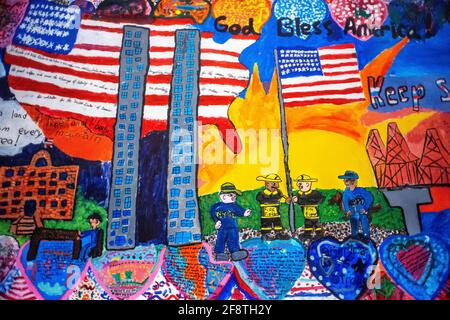 A giant mural of a firefighters polices and the original World Trade Center building inside 9/11 Memorial and Museum interior - looking down at The La Stock Photo