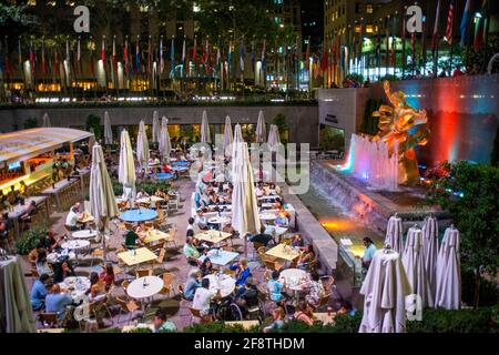 The rink at the Rockefeller Center and the summer garden Bar and restaurant and The statue of the Titan God, Prometheus sits above the sunken plaza at Stock Photo