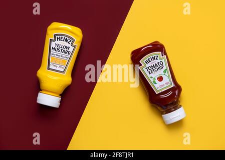 Heinz Ketchup bottle and bottle of Heinz Yellow Mustard on a red and yellow background Stock Photo