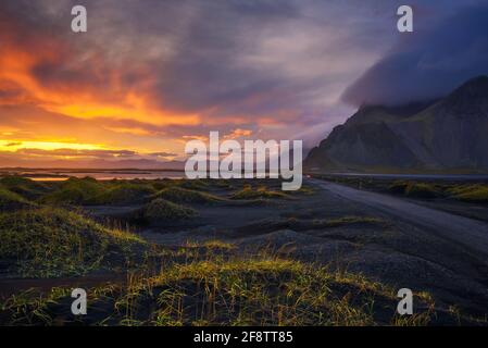 Gravel road at sunset with Vestrahorn mountain in the background, Iceland Stock Photo